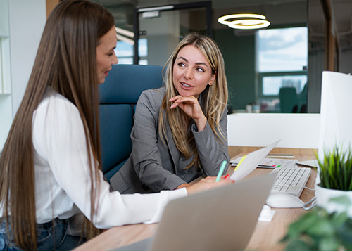 two women talking at working on client project